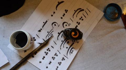 Ink, pen and paper with Arabic calligraphy