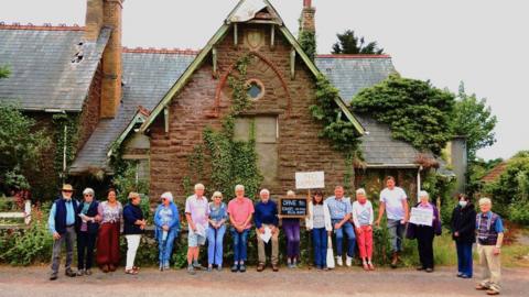 A row of people standing in front of the Old School