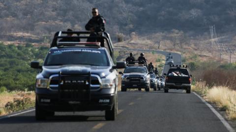 A State police convoy patrols a road in El Aguaje after a visit of Vatican's ambassador to Mexico Franco Coppola to the area and to the municipality of Aguililla, an area where the Jalisco New Generation Cartel (CJNG) and local drug gangs are fighting to control the territory, in Michoacan state, Mexico April 23, 2021.