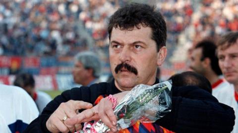 Former Steaua Bucharest goalkeeper Helmuth Duckadam gestures after receiving flowers before an anniversary rematch of the 1986 European Cup final between Steaua and Barcelona