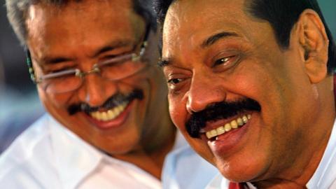 Sri Lankan President Mahinda Rajapakse (R) and Sri Lankan Defence Ministry Secretary Gotabaya Rajapaksa (L) walk past Buddhist monks during the War Heroes religion ceremony in Colombo on May 9, 2013.