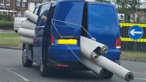 Van overloaded with rolls of carpet