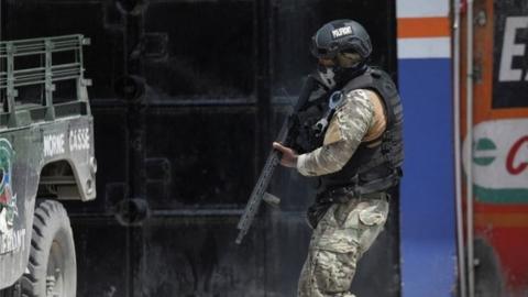 A member of the Haitian National Police patrols a street as ongoing gun battles between rival gangs have forced residents to flee their homes, in Port-Au-Prince, Haiti April 28, 2022.