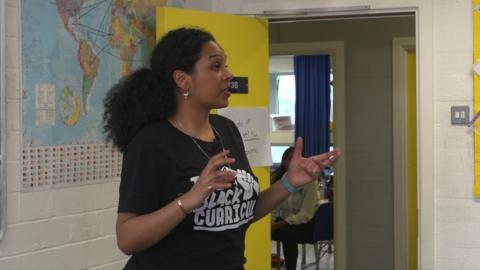 A woman teaching black history to students