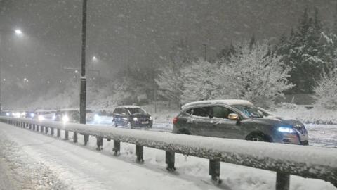 Cars are seen stuck on the North Circular as heavy snow falls in London on Monday