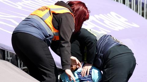 Swansea stewards remove a fan wearing a Wycombe Wanderers shirt from Liberty Stadium
