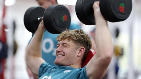 Fin Smith lifting weights during an England training session