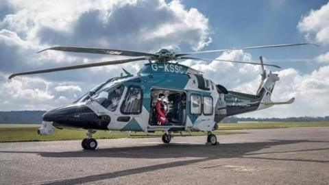 The image shows a helicopter in a runway.