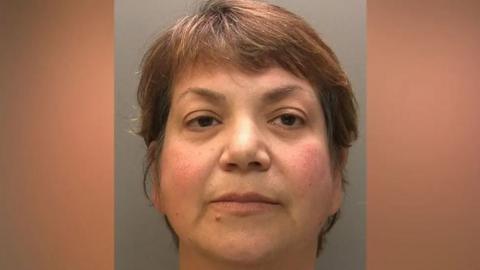Police custody shot of Zholia Alemi with short brown hair and eyes.