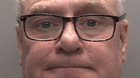 Mugshot of Francis Ventre, who has dark glasses and short white hair.