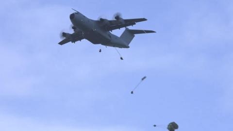 One of the aircraft dropping parachutes during the training. The sky is clear.