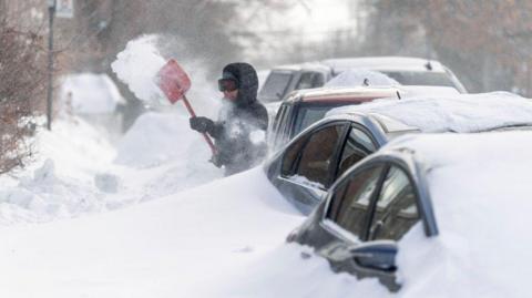 People dig out cars in Canada following two snow storms