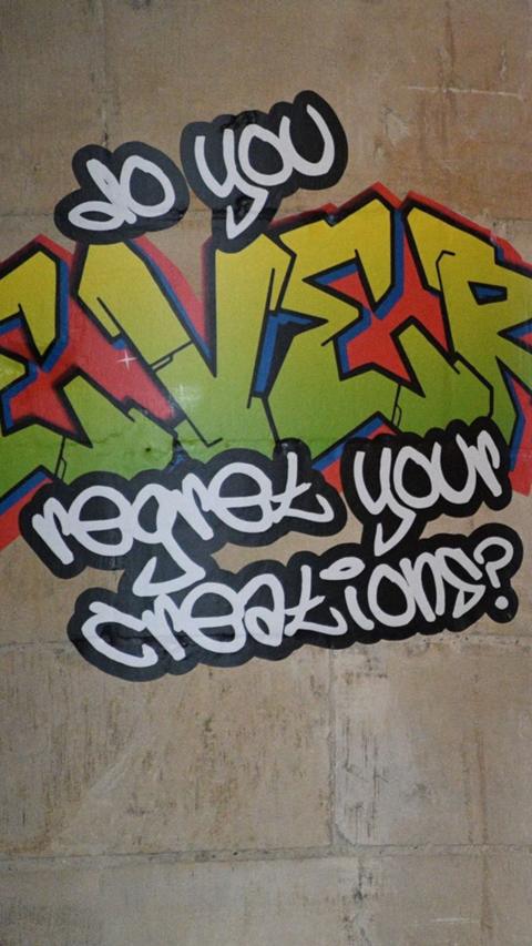 A sticker on a cathedral pillar. It says in a graffiti text: "Do you ever regret your creations?"