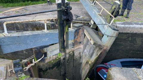 Damaged gates that have fallen into a canal lock leaving a boat stranded