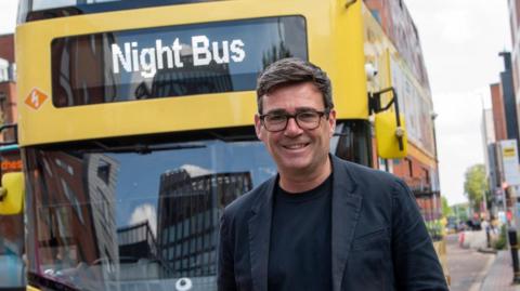 Andy Burnham in front of a Bee Network bus