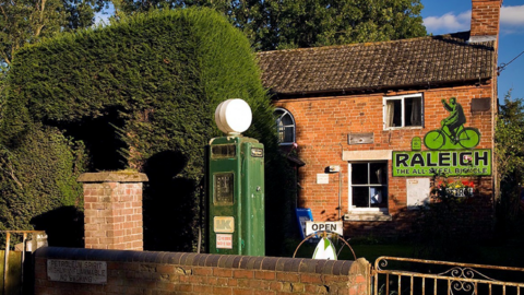 An old fashioned petrol pump outside a house