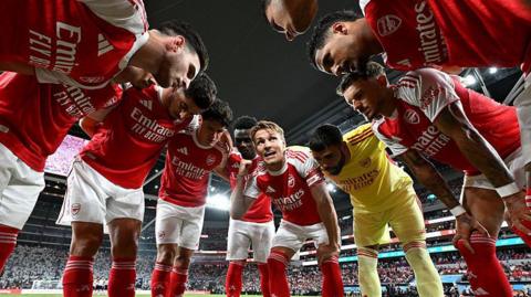 Arsenal players talk in a huddle