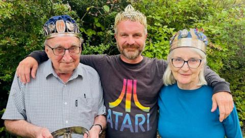 Coronau: Owain Rhys gyda'i fam Manon Rhys a'i lystad Jim Parc Nest