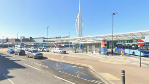 The Spinnaker Tower rises behind the canopy of the bus station in The Hard.