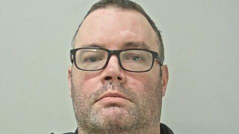 Thomas Freret has dark-framed glasses, stubble and short dark hair.
