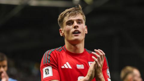 Wales defender Dylan Lawlor applauds
