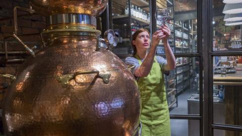 A woman working in a gin distillery