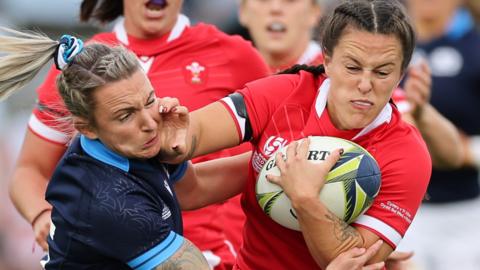 Ffion Lewis of Wales is tackled by Chloe Rollie of Scotland
