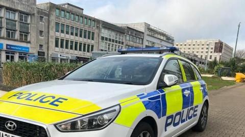 A police car parked on a street in Plymouth