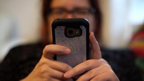 A stock image of a woman holding a phone 