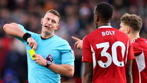 Match Referee Robert Jones shows a second yellow card to Willy Boly