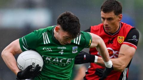 Fermanagh's Oisin Smyth attempts to fend off Down's Pat Havern at Brewster Park
