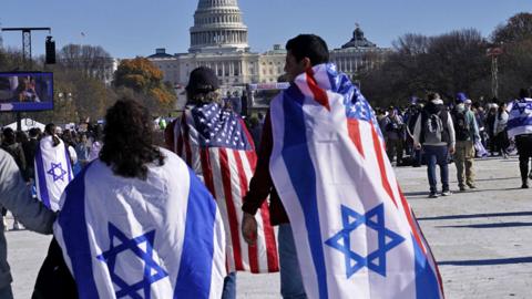 People wearing Israeli flags walk towards the Capitol