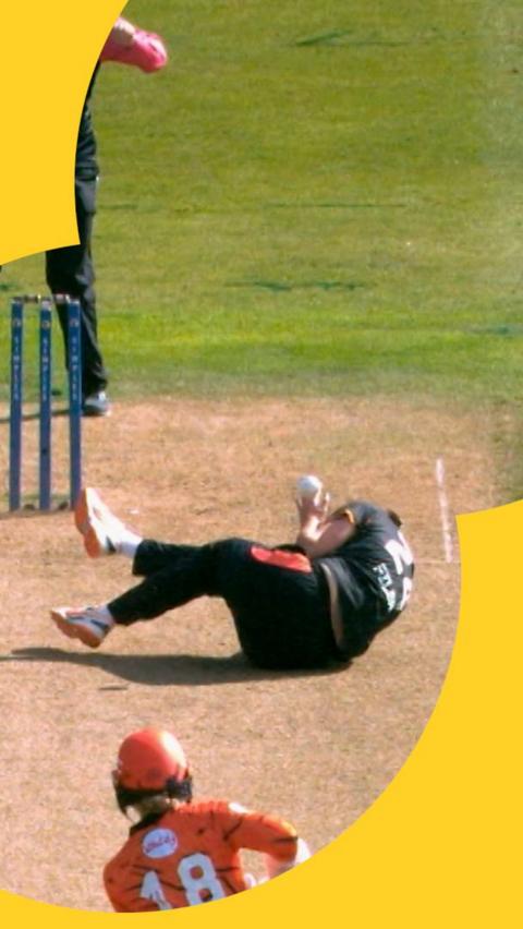 Lauren Filer curled up on the floor as the ball brushes over the top of her head