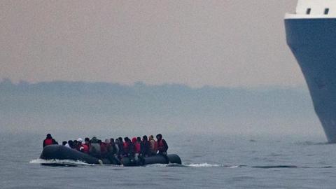 People ride in a boat across the English Channel