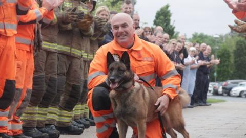 Frankie the retiring service dog with her handler Steven Carr, flanked by members of TWFRS