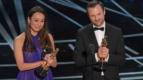 Producer Joanna Natasegara and director Orlando von Einsiedel accept their Oscar award