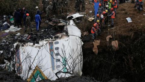 Rescue workers at the site of the Yeti Airlines crash that killed 72