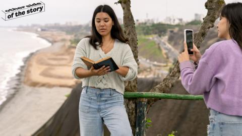 Woman reading book while being filmed