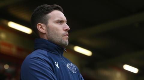 Mat Sadler watches on from the touchline during a Walsall game
