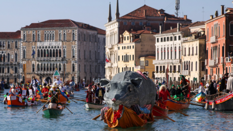 A boat carries a "Pantegana", the big rat, as revellers row during the masquerade parade on the Grand Canal during the Venice Carnival, in Venice, Italy,