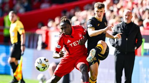 Emmanuel Gymafi and Lewis Smith battle for possession