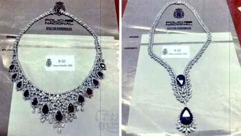Silver necklaces are displayed in cabinets against a white backdrop