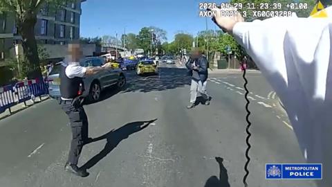 Body-worn footage shows two police officers approaching suspect in the middle of street
