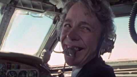 Yvonne Pope Sintes sits in the cockpit of a plane, wearing a headset