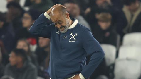 Nuno Espirito Santo looks downwards with his right hand clasped to the top of his head during West Ham's defeat