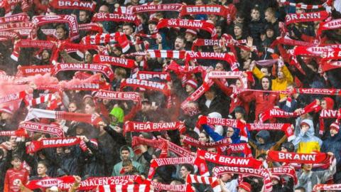Brann fans holding up scarves in stand