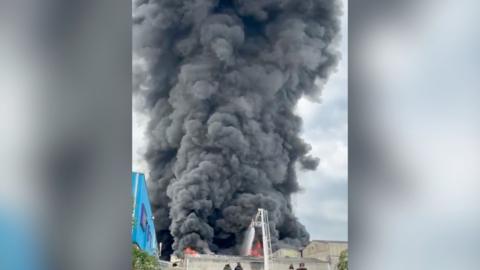 Smoke billows into the sky from an industrial estate fire.