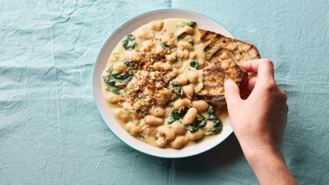 Cheesey butter beans in a bowl with toast