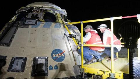 Boeing and NASA teams work around the Starliner spacecraft after it landed on Saturday