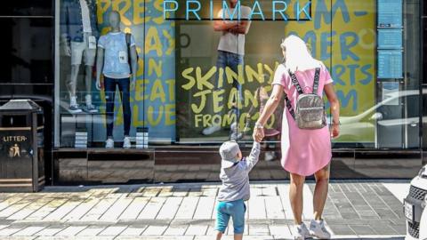 Woman and child in front of a Primark store